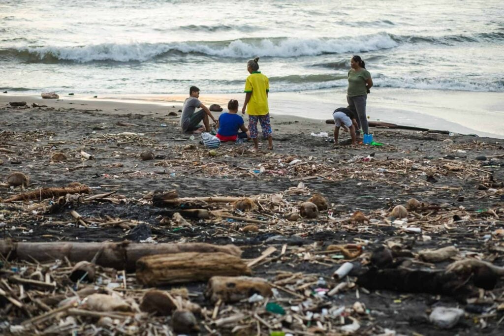 Beach pollution in Bali. Hard life of local people around garbage on the beach.