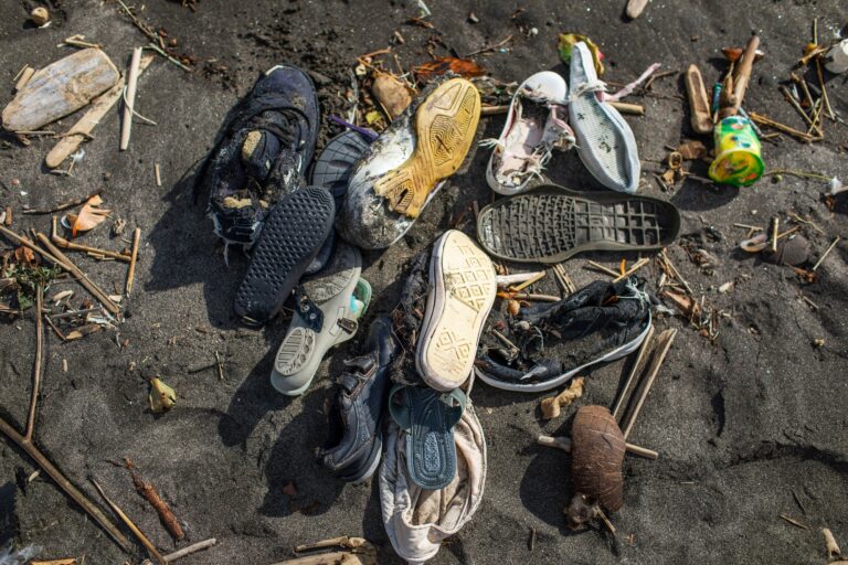 Environmental pollution. Heap of used rubber shoes on the beach in Bali, Indonesia.