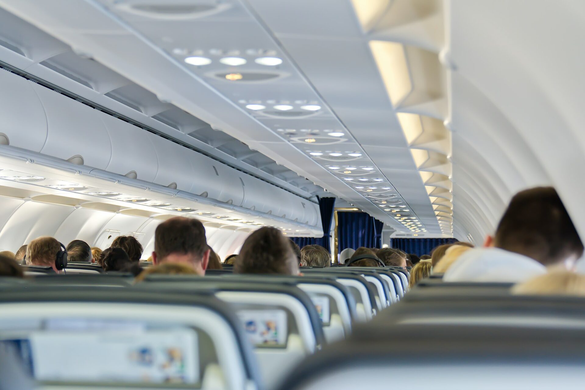 Interior of Airplane Cabin with Passengers Boarding or Deboarding at the Airport