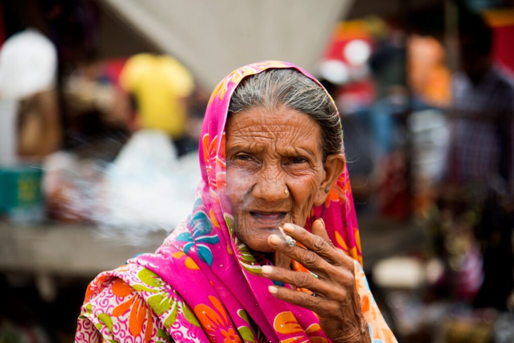 Old age woman smoking Indian handmade cigarette.